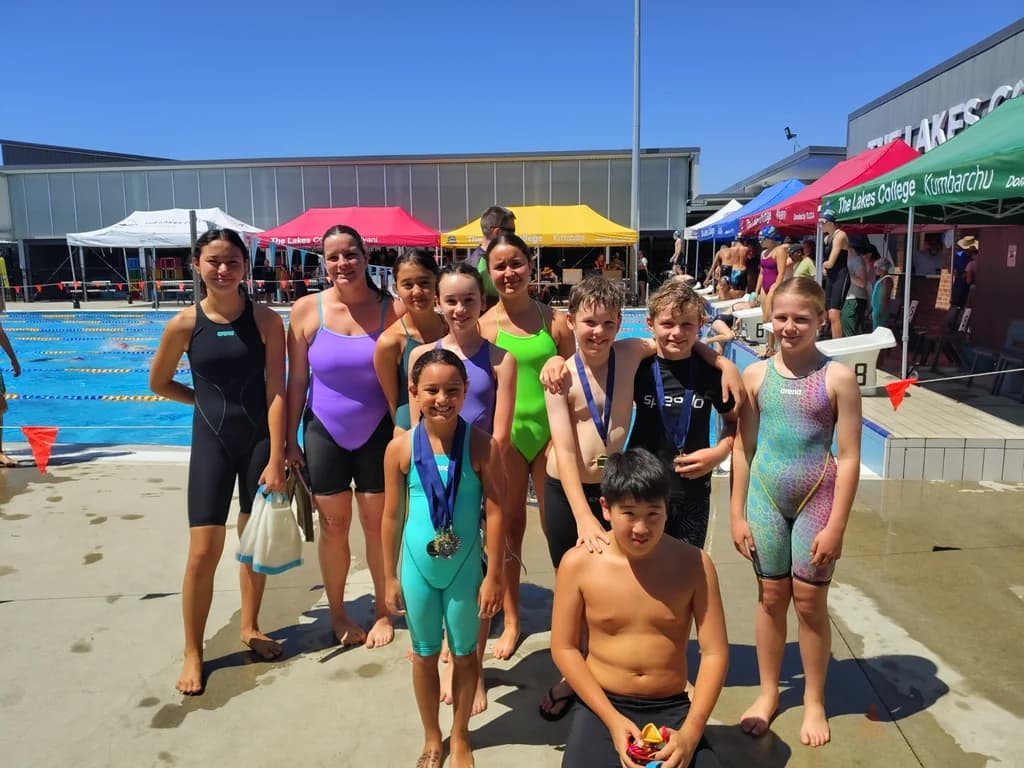 RK Swimming squad swimmers together by the pool at The Lakes swim meet
